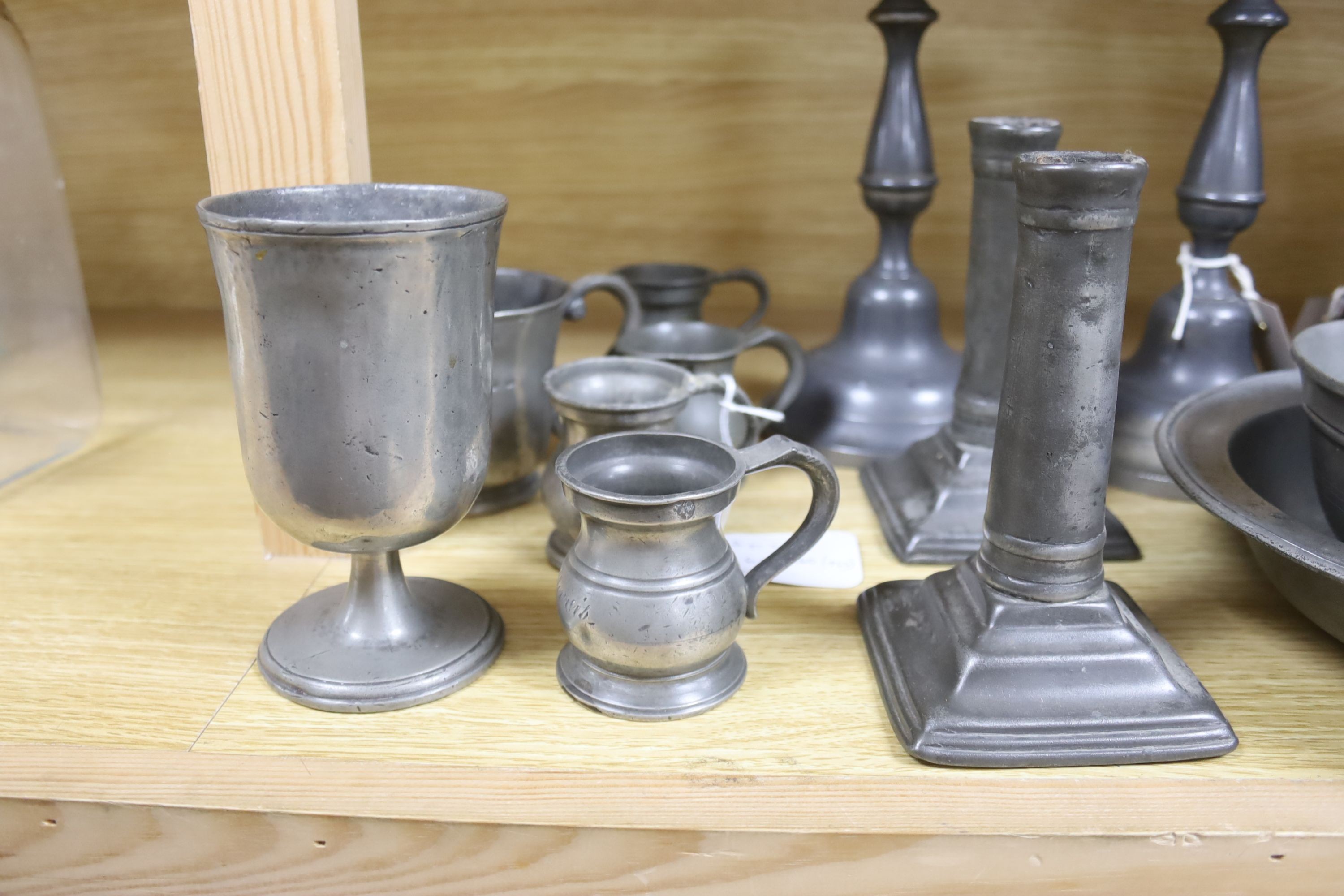 A French lidded pewter jug with double acorn thumbpiece, two pairs of pewter candlesticks and nine other items of pewter (14)